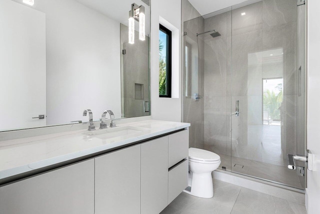 bathroom featuring toilet, a stall shower, plenty of natural light, and vanity