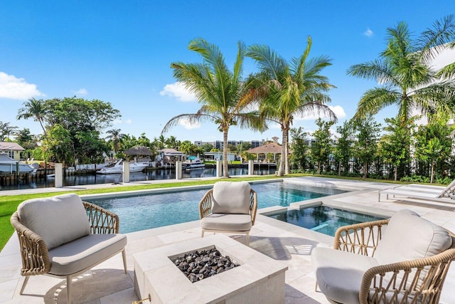 view of pool featuring a water view, an outdoor fire pit, a patio, and an in ground hot tub