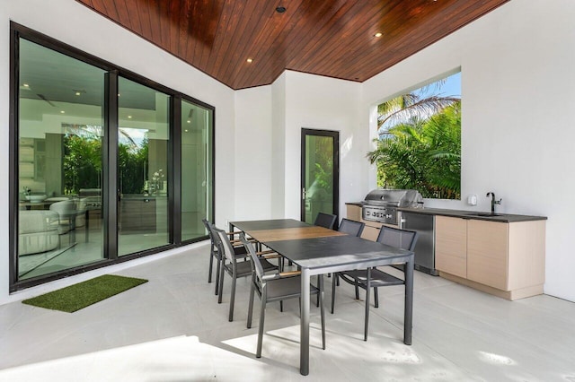 view of patio featuring exterior kitchen, outdoor dining area, a sink, and area for grilling