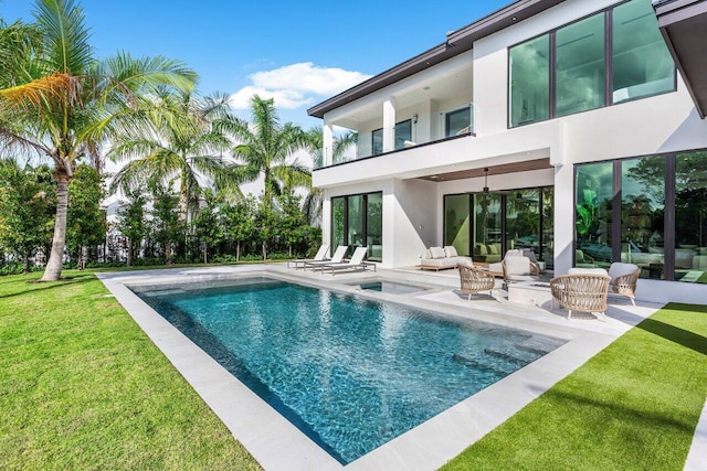 outdoor pool with ceiling fan, an outdoor living space, a lawn, and a patio