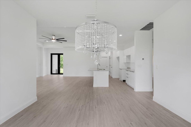 604 Lake Ave, Lehigh Acres, FL 33972 - unfurnished living room featuring light wood-type flooring and ceiling fan with notable chandelier