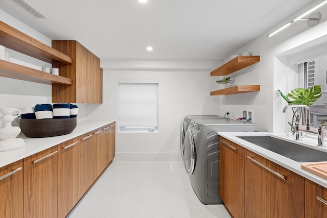 clothes washing area featuring separate washer and dryer and sink