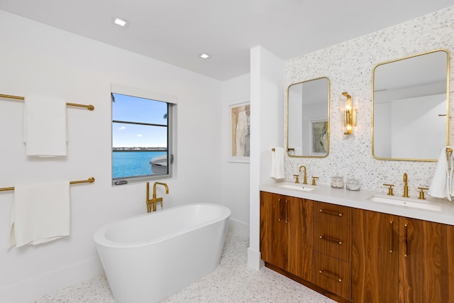 bathroom with a water view, vanity, backsplash, and a washtub