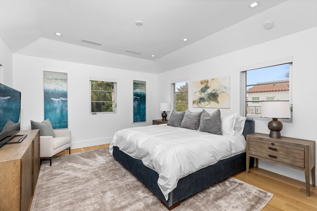 bedroom featuring lofted ceiling and light wood-type flooring
