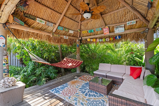 wooden terrace featuring ceiling fan, a gazebo, and an outdoor hangout area