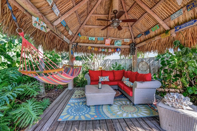 wooden terrace featuring ceiling fan, a gazebo, and an outdoor hangout area