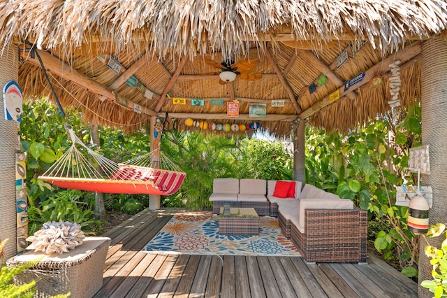 wooden deck with outdoor lounge area, a gazebo, and ceiling fan