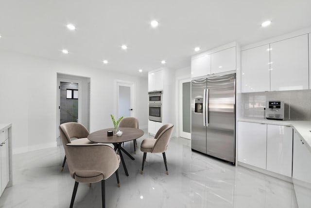 kitchen featuring tasteful backsplash, white cabinets, modern cabinets, stainless steel appliances, and recessed lighting