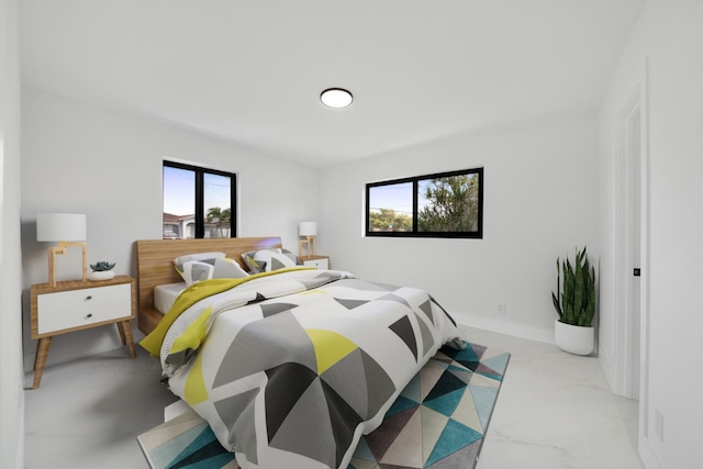 bedroom featuring marble finish floor, multiple windows, and baseboards