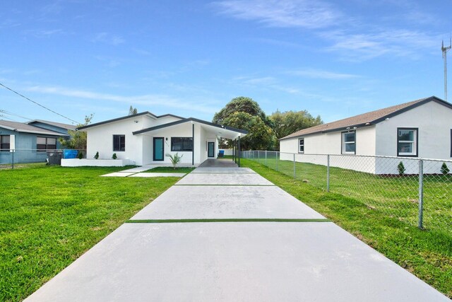 view of front facade featuring driveway, fence private yard, stucco siding, and a front yard