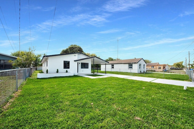 view of front of home featuring a fenced backyard, a front lawn, and stucco siding