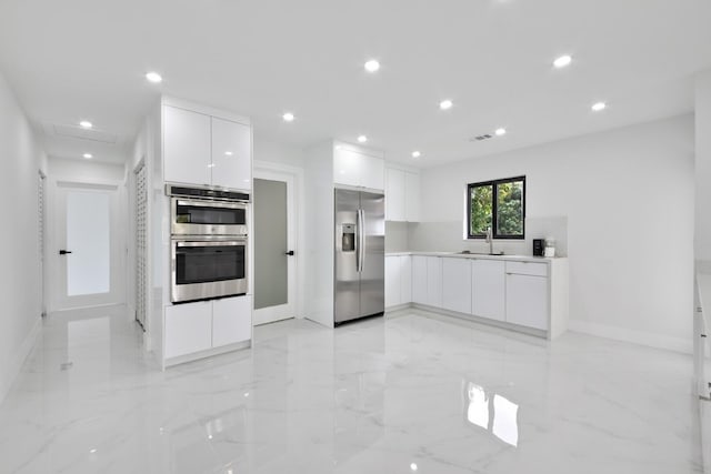 kitchen featuring marble finish floor, white cabinetry, modern cabinets, and appliances with stainless steel finishes