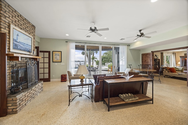 living room with a brick fireplace and ceiling fan