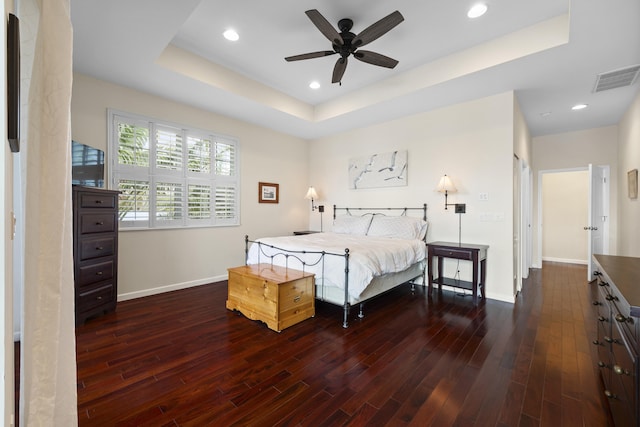 bedroom featuring a raised ceiling and dark hardwood / wood-style floors