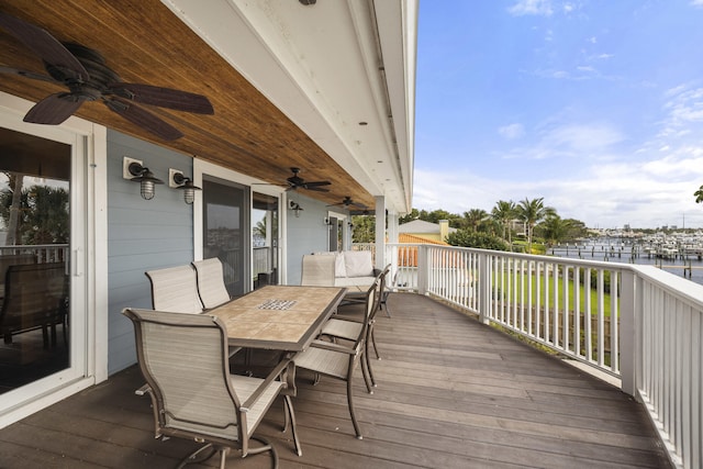 wooden terrace featuring a water view and ceiling fan