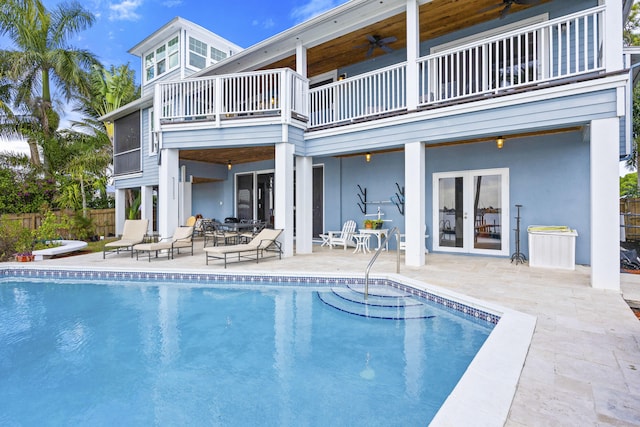 back of house with a patio, a fenced in pool, a balcony, ceiling fan, and french doors