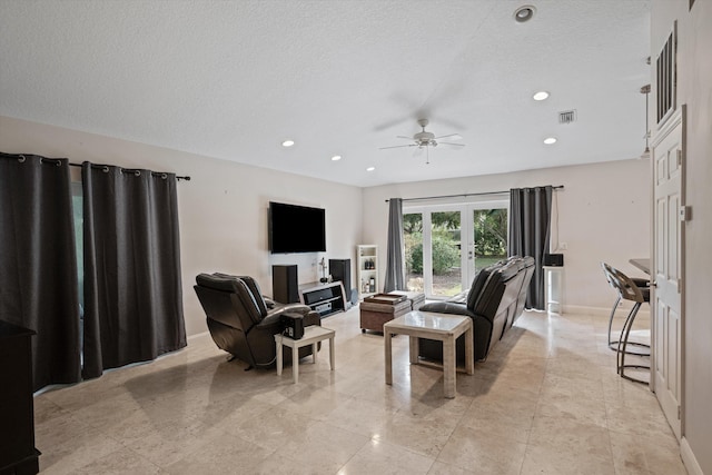 living room featuring a textured ceiling, french doors, and ceiling fan