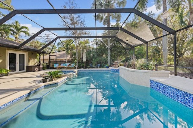 view of swimming pool featuring french doors, a lanai, and a patio area