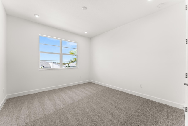 carpeted empty room featuring baseboards and recessed lighting
