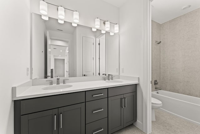 full bath with double vanity, a sink, toilet, and tile patterned floors