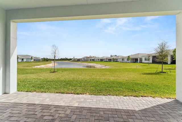 view of yard with a residential view and a water view