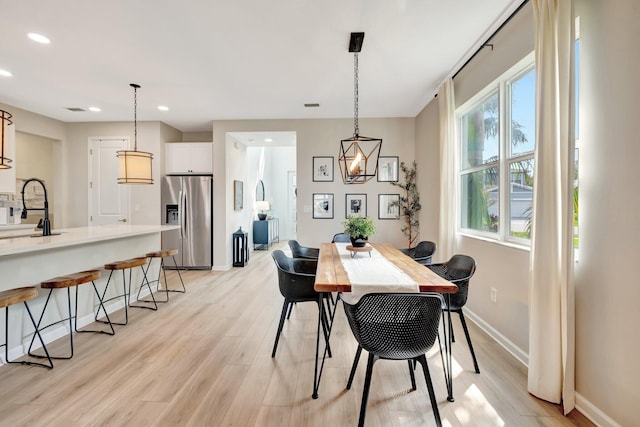 dining room featuring recessed lighting, baseboards, visible vents, and light wood finished floors