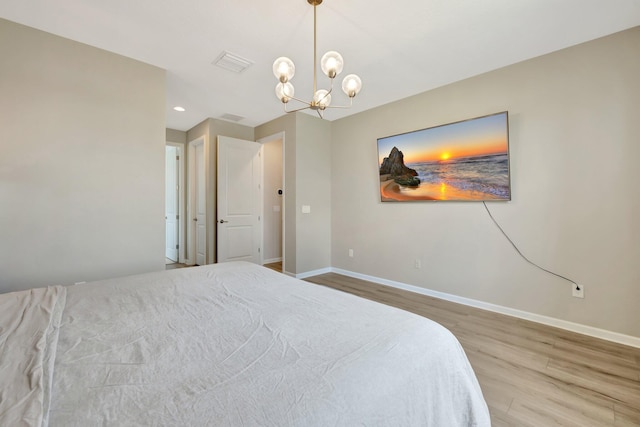 bedroom with visible vents, baseboards, a chandelier, and wood finished floors