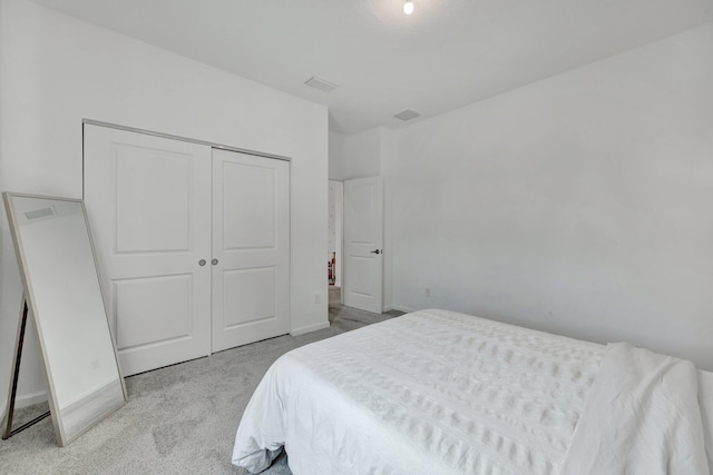 carpeted bedroom featuring a closet, visible vents, and baseboards