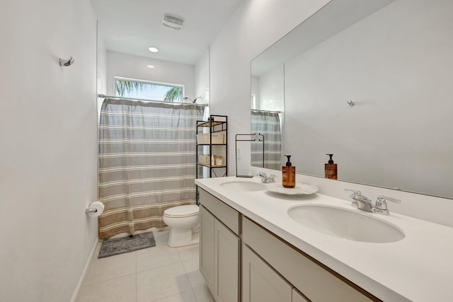 bathroom featuring tile patterned flooring, curtained shower, a sink, and toilet