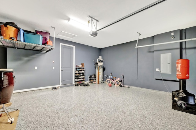 garage featuring a garage door opener, electric panel, and baseboards