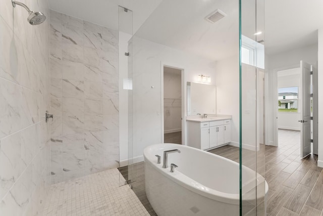 full bath with a soaking tub, visible vents, a spacious closet, vanity, and a walk in shower