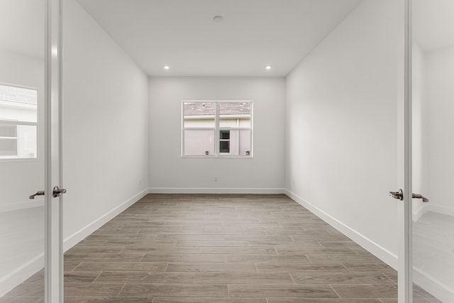 empty room featuring recessed lighting, french doors, baseboards, and wood finished floors