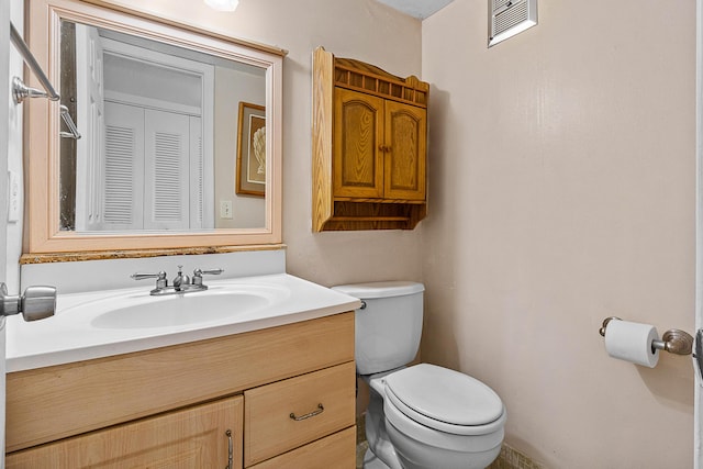 bathroom with visible vents, toilet, and vanity