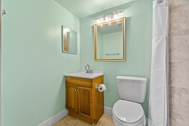 bathroom featuring baseboards, toilet, a tile shower, tile patterned floors, and vanity