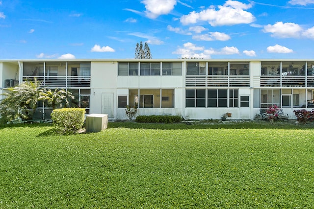 rear view of house with a yard and a sunroom