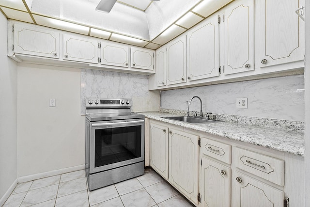 kitchen featuring light countertops, light tile patterned floors, decorative backsplash, stainless steel electric range, and a sink