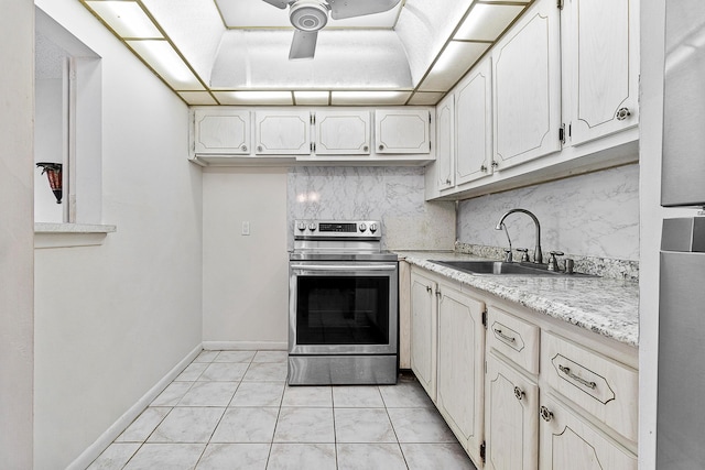 kitchen with a ceiling fan, stainless steel electric range, a sink, light countertops, and tasteful backsplash