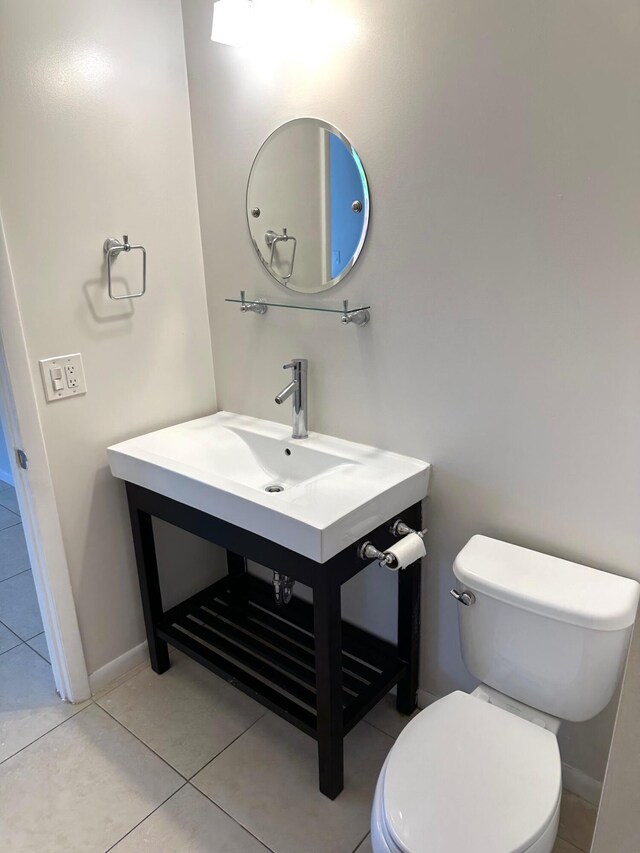 bathroom featuring a textured ceiling, tile patterned flooring, toilet, baseboards, and water heater