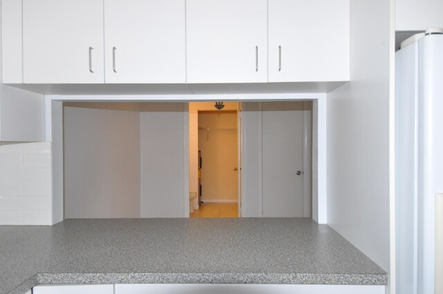 empty room with a healthy amount of sunlight, light tile patterned floors, stairway, and ceiling fan with notable chandelier