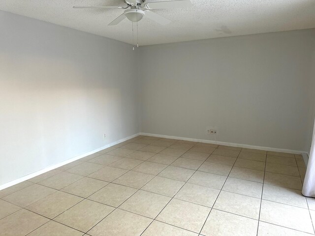 unfurnished room featuring ceiling fan, light tile patterned floors, visible vents, baseboards, and stairs