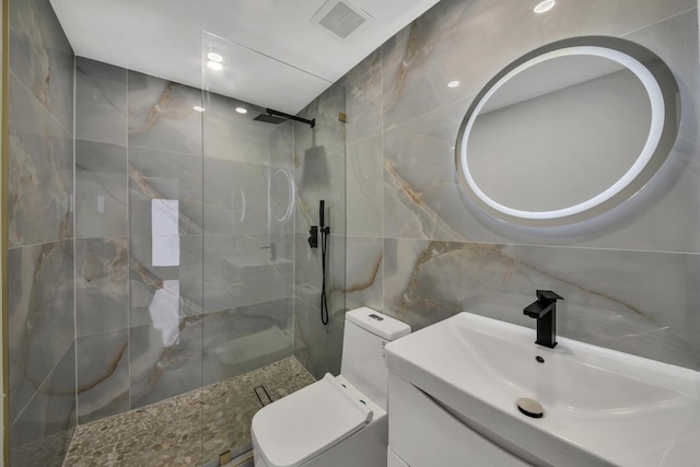 full bath featuring a marble finish shower, visible vents, toilet, vanity, and tile walls