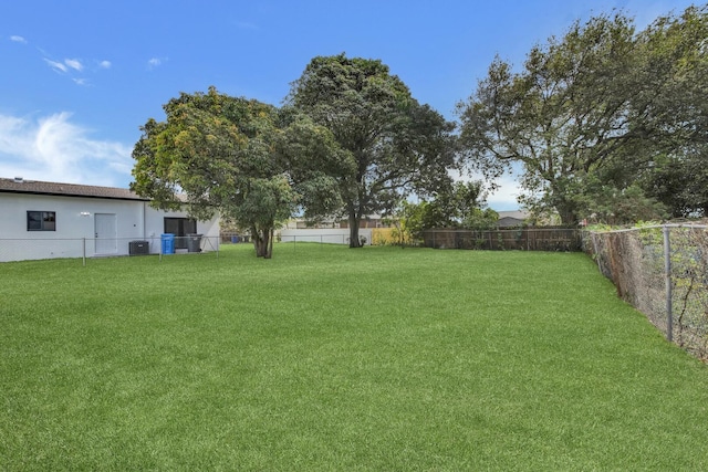 view of yard featuring central AC and a fenced backyard