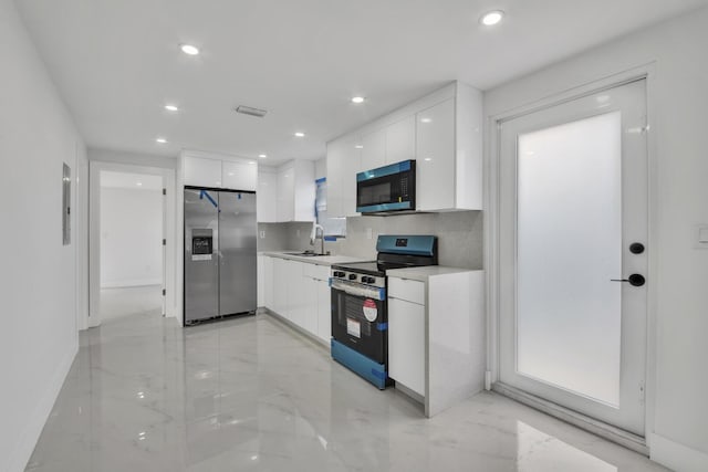 kitchen with appliances with stainless steel finishes, white cabinets, a sink, and modern cabinets