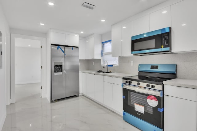 kitchen featuring stainless steel appliances, modern cabinets, a sink, and light countertops