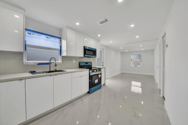 kitchen featuring visible vents, electric range, white cabinetry, a sink, and modern cabinets