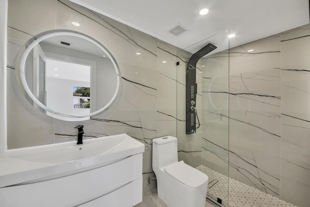 bathroom featuring toilet, vanity, visible vents, tile walls, and a marble finish shower