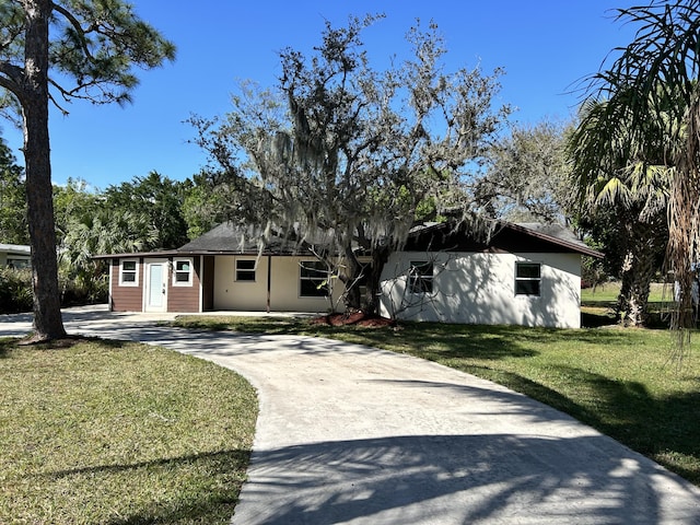 single story home featuring driveway and a front lawn