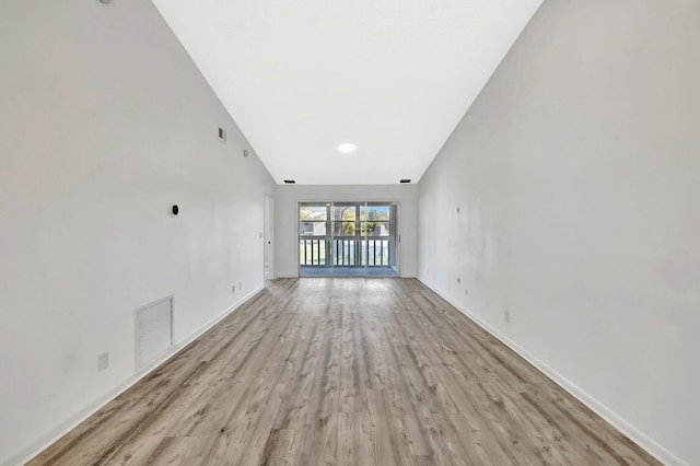 unfurnished living room featuring visible vents, light wood-style flooring, and baseboards