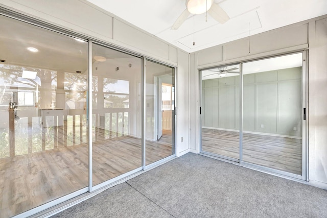 unfurnished sunroom featuring a ceiling fan