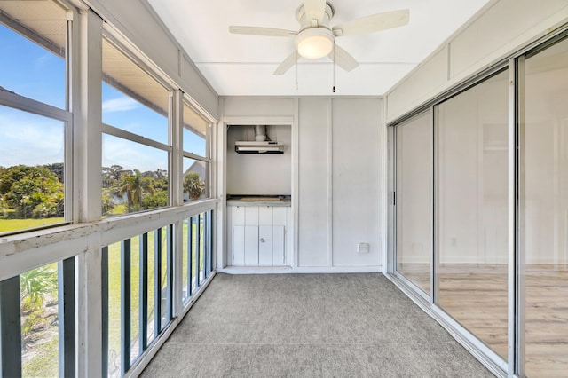 unfurnished sunroom featuring ceiling fan